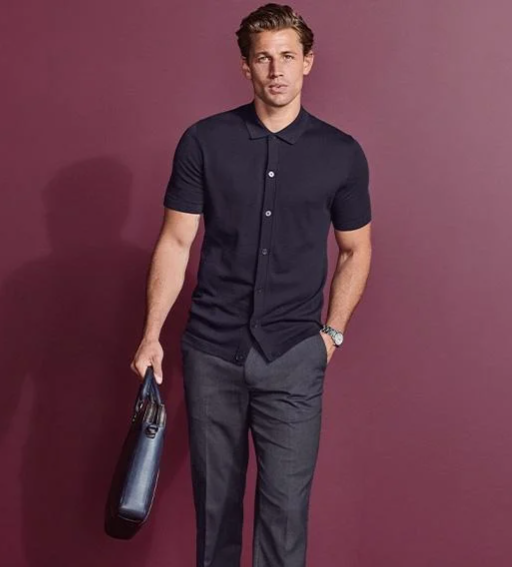 Man wearing navy short sleeve shirt with grey trousers holding a briefcase