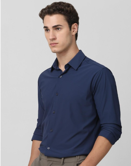 Man wearing navy blue formal shirt with slim fit and neutral background