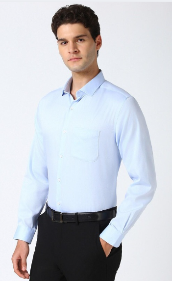 Man wearing light blue formal shirt with black trousers in clean studio setting