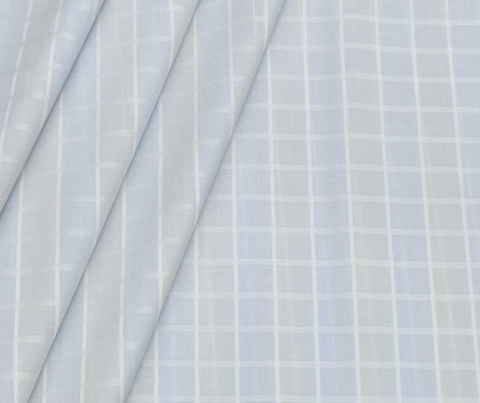Light blue cotton fabric texture with subtle check pattern for shirt material