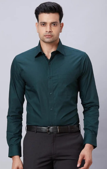 Man wearing dark green formal shirt with black trousers in studio background
