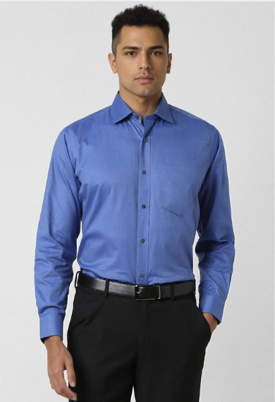 Man wearing blue formal shirt with black trousers in clean studio background