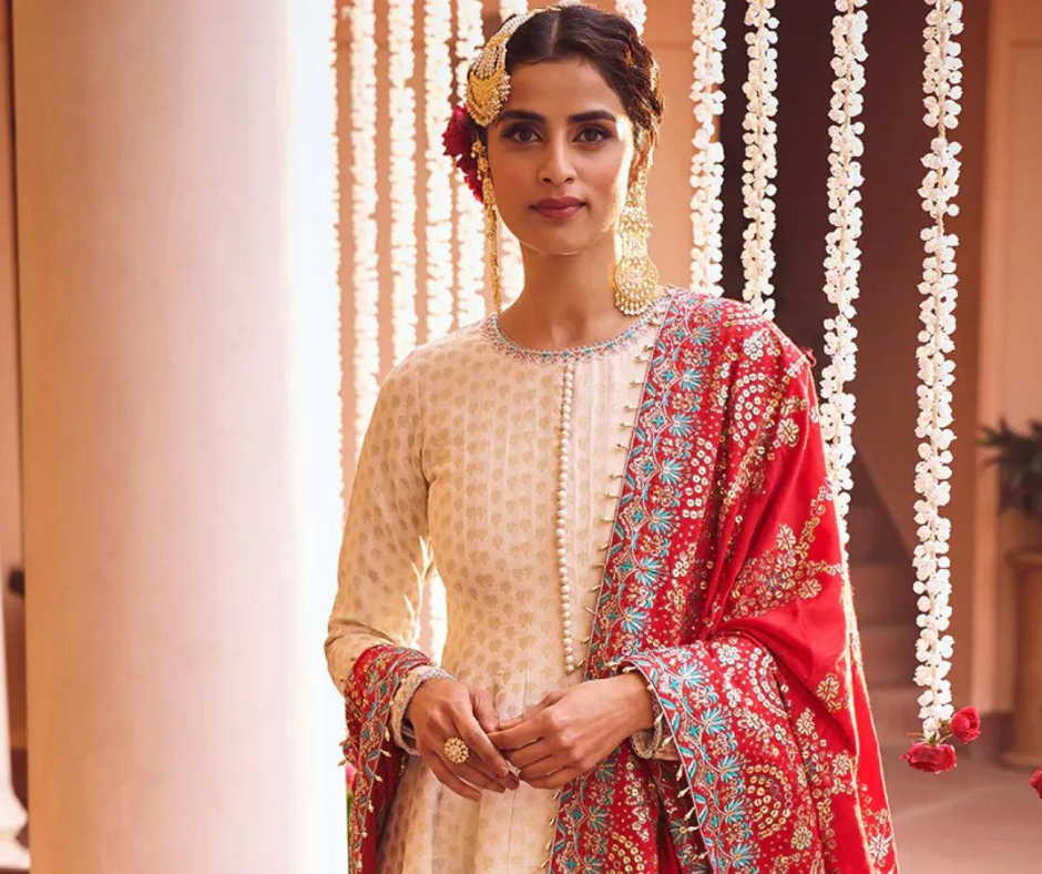 Woman wearing elegant traditional Indian ethnic outfit with embroidered dupatta in festive setting
